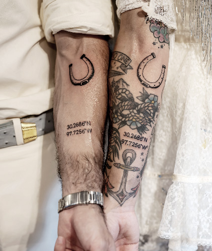 Couple shows matching horseshoe and coordinate tattoos on their forearms