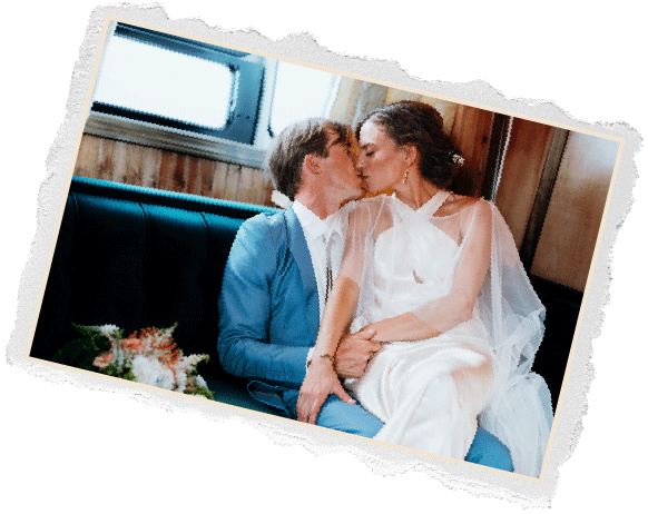 Torn edge photo of a bride and groom kissing on a vintage trailer bench