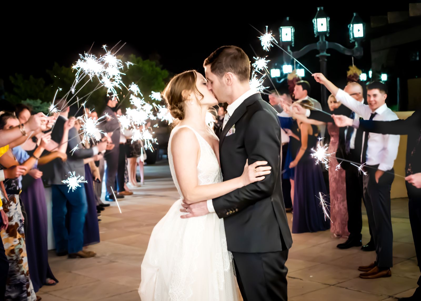 Couple kissing during a sparkler send off