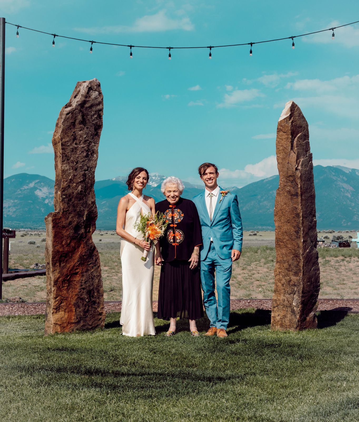 Bride and groom with an older relative between two standing stones